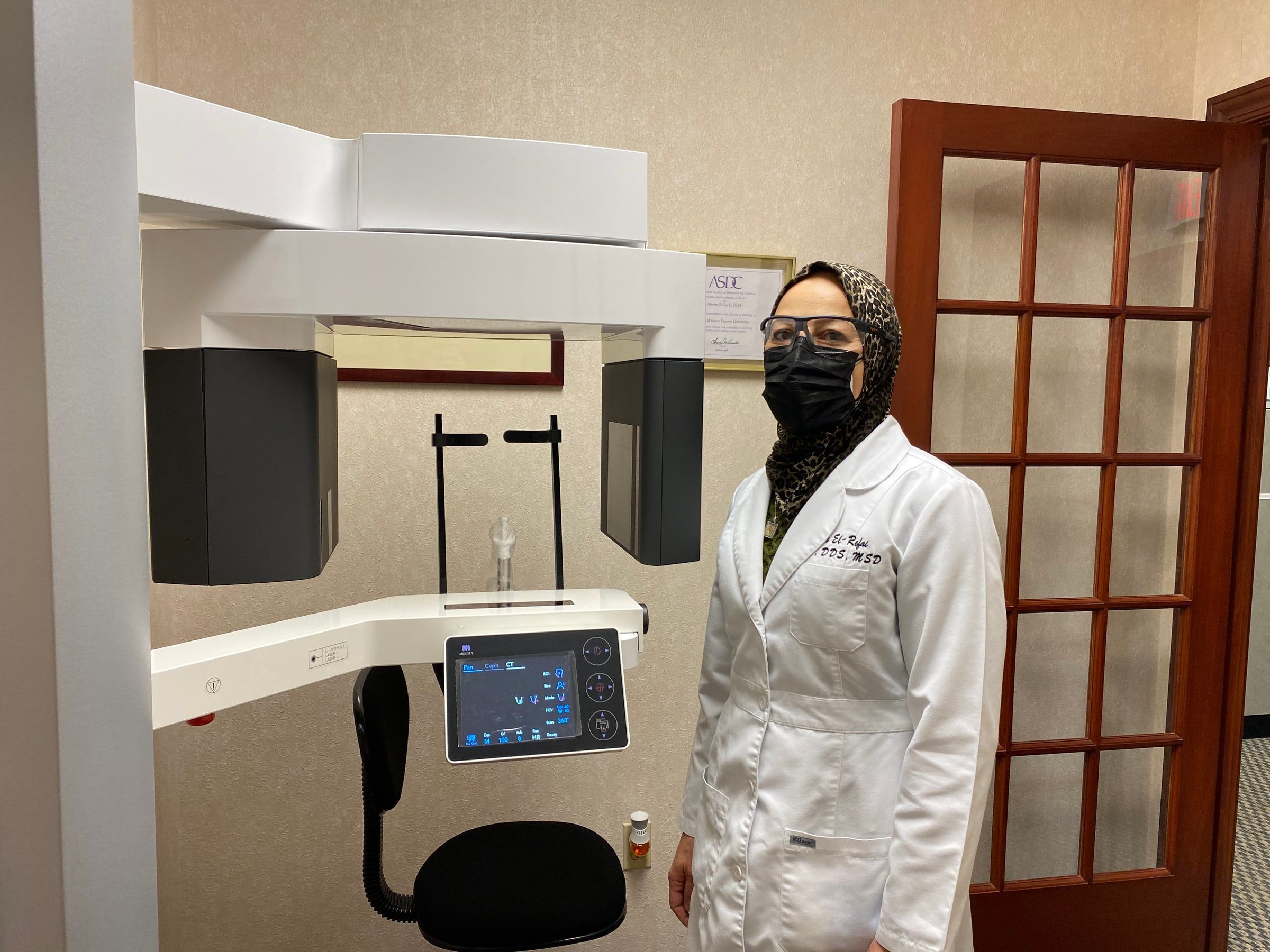 Dr. El-Refai beside the small-field 3D cone beam scanner in her office